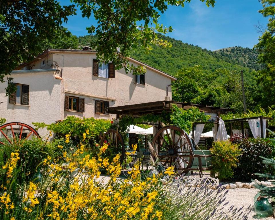 a house with a garden with chairs and flowers at B&B LE GRETTE in Gioia dei Marsi
