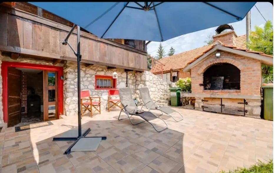 a blue umbrella sitting on a patio in front of a building at Slavotova hiža in Mračin