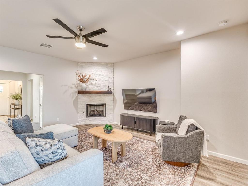 a living room with a couch and a fireplace at Kingsport Modern Oasis in Broken Arrow