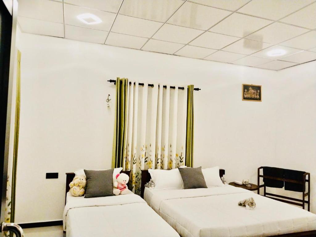 a room with two beds with teddy bears on them at S & B Villa Weligama in Weligama