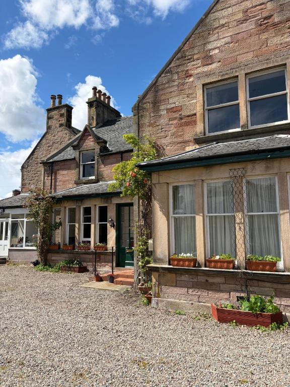 an old brick house with windows and potted plants at Kinkell House in Inverness