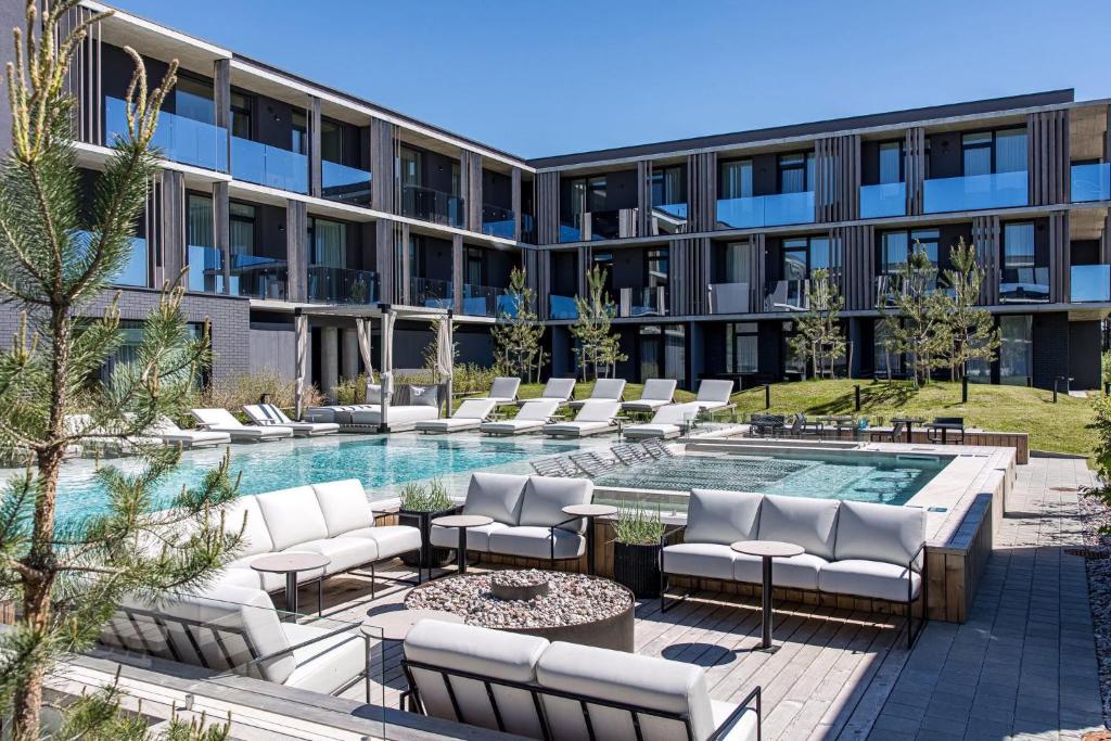 an apartment building with a pool and lounge chairs at Infinutum Sea Studio in Palanga