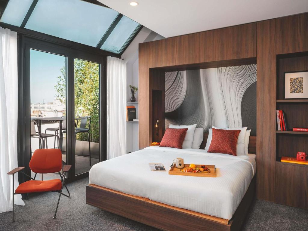 a bedroom with a bed and a table and a chair at Novotel Paris Vaugirard Montparnasse in Paris
