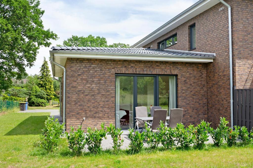 a house with a patio with chairs and a table at Auszeit in der Heide mit Terrasse in Bienenbüttel