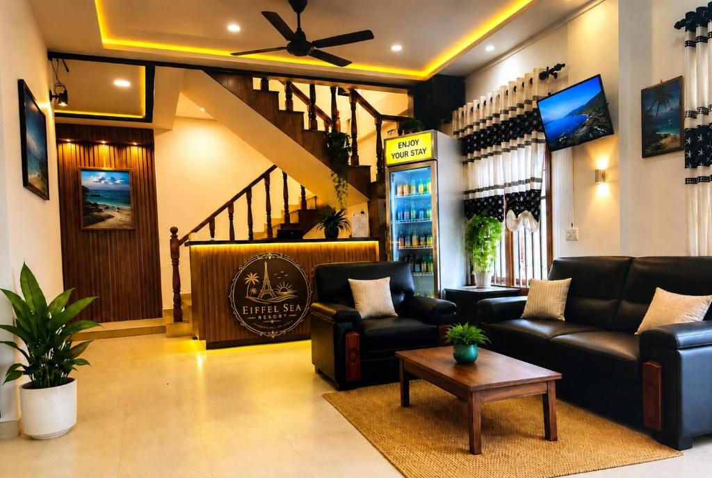 a living room with couches and a table and stairs at Eiffel Sea Resort in Trincomalee
