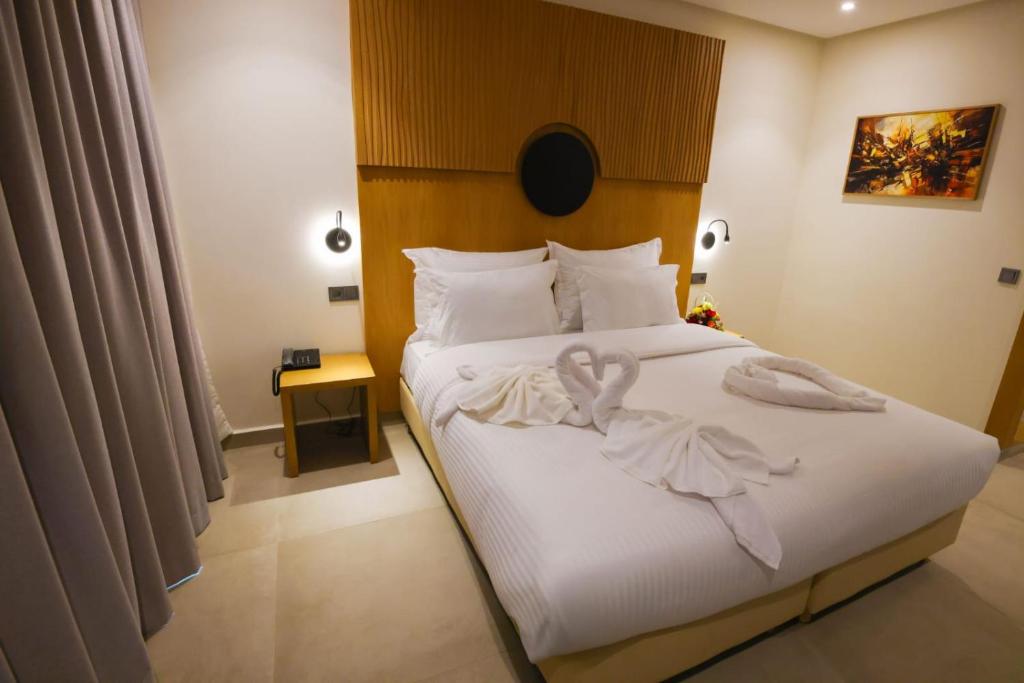 ein Schlafzimmer mit einem Bett, auf dem zwei Handtücher liegen in der Unterkunft FAHO Hôtel in Rabat