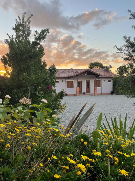 a house with a lot of flowers in front of it at Sentiero Lofts in Urubici