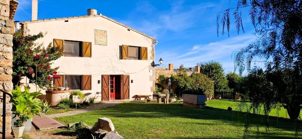 a large white house with a grass yard at La Masia Costa Brava -Adults Only in Garrigás