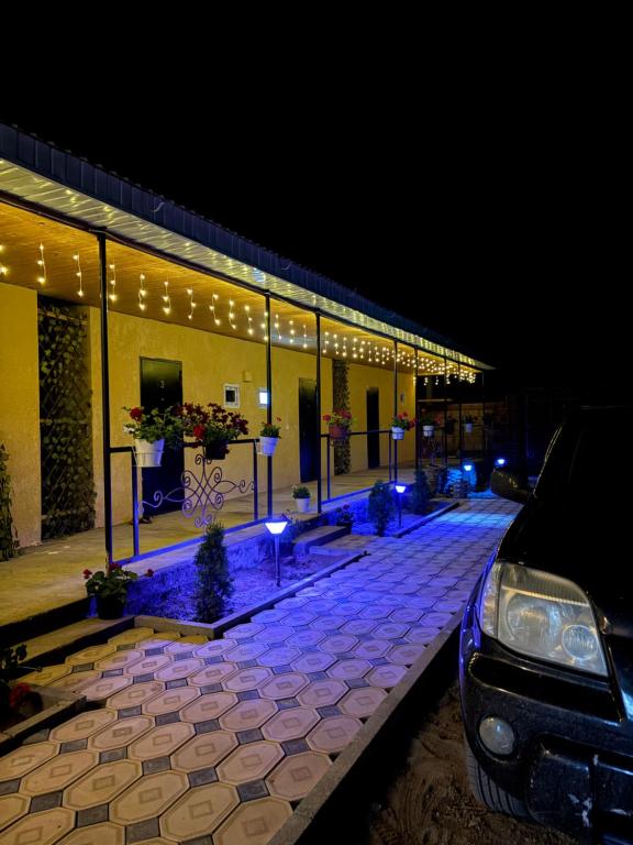 a car parked in front of a building at night at Guest House Nurdana in Tossor
