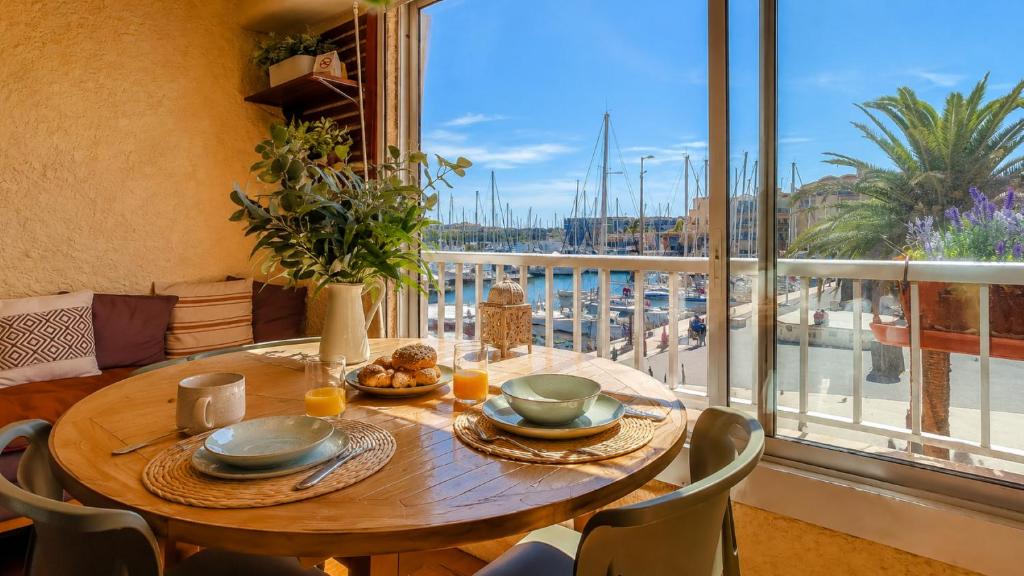 a dining room table with a view of a harbor at TERRASSE Vue MARINA - PARKING Privé - Port Commerces & PLAGE à PIED - Vue Exceptionnelle - RétroMirabeau "Côté Mer" in Gruissan