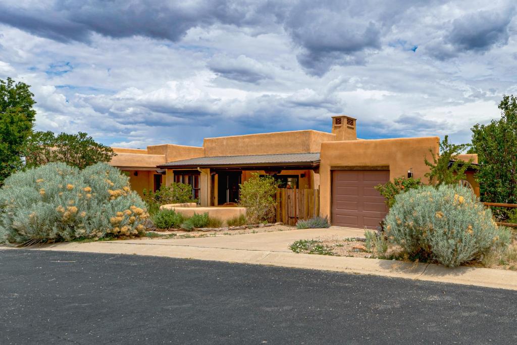 a brown house with a garage on a street at Adobe-Style Taos Home with Great Views! in Taos