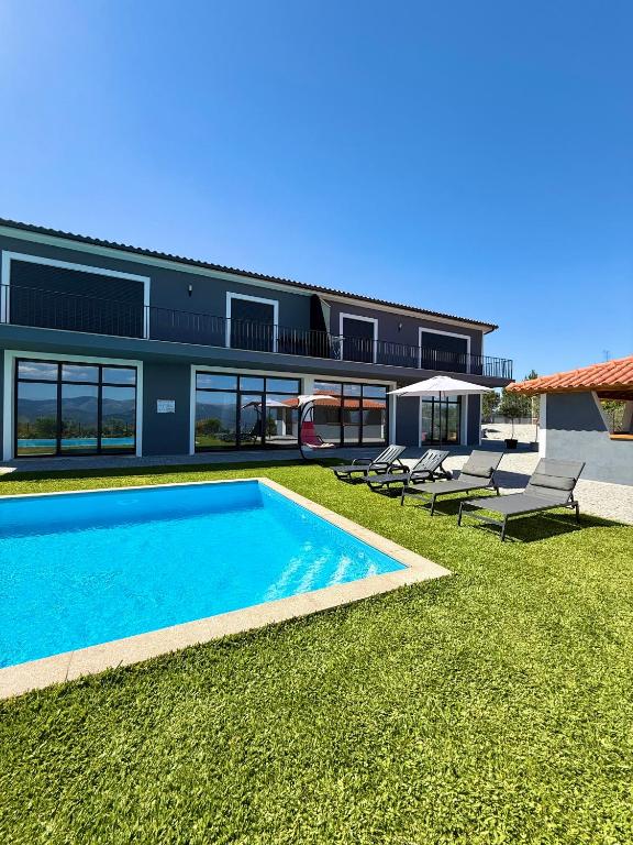 a house with a swimming pool next to a building at Paraíso Céu Azul in Celorico de Basto