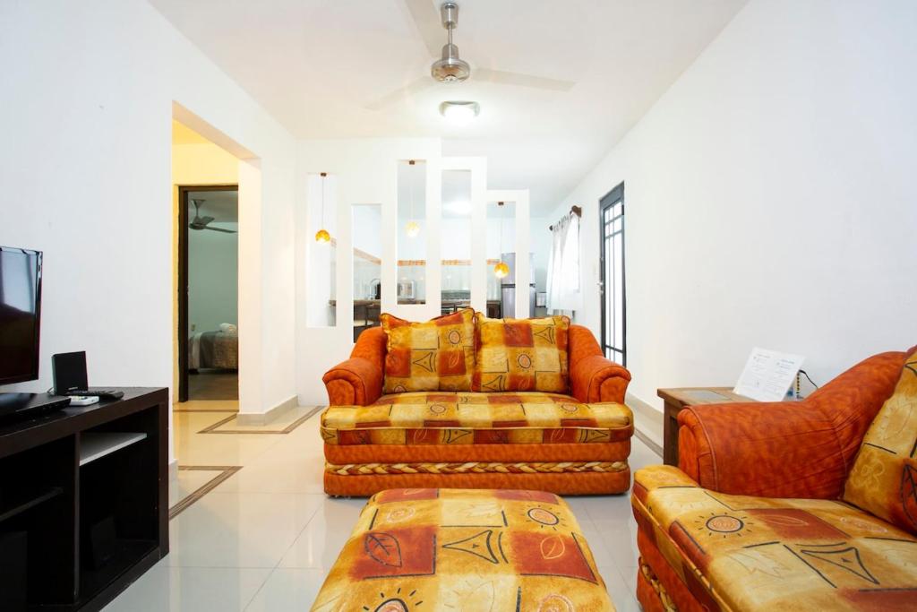 a living room with two couches and a tv at La Casita Perfect Location in Cozumel