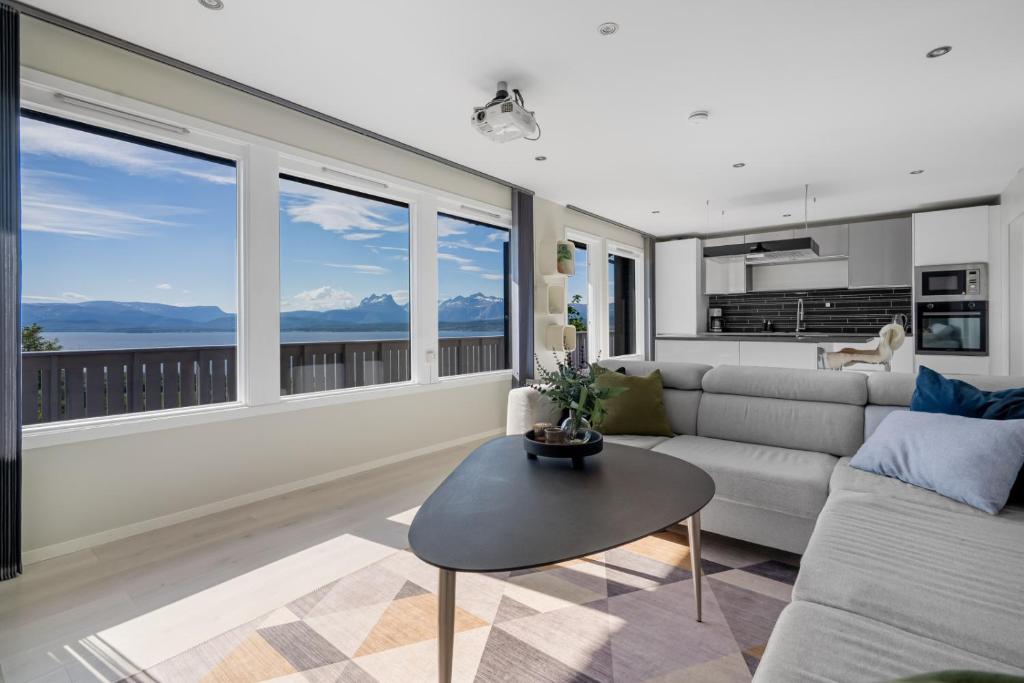 a living room with a couch and a table at Panorama view! Modern,Balcony/parking in Bodø