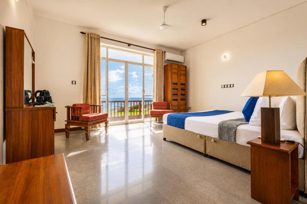 a hotel room with a bed and a balcony at Fisherman's Cove in Wattala