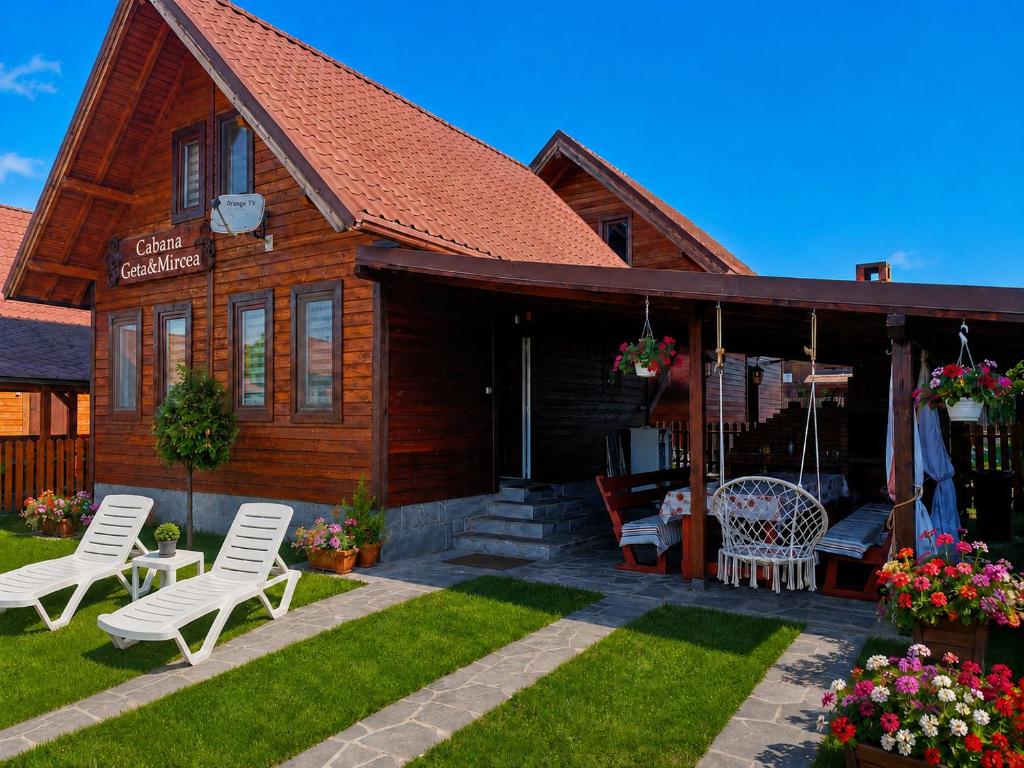 a house with white chairs and a patio at Cabana Geta&Mircea in Beclean