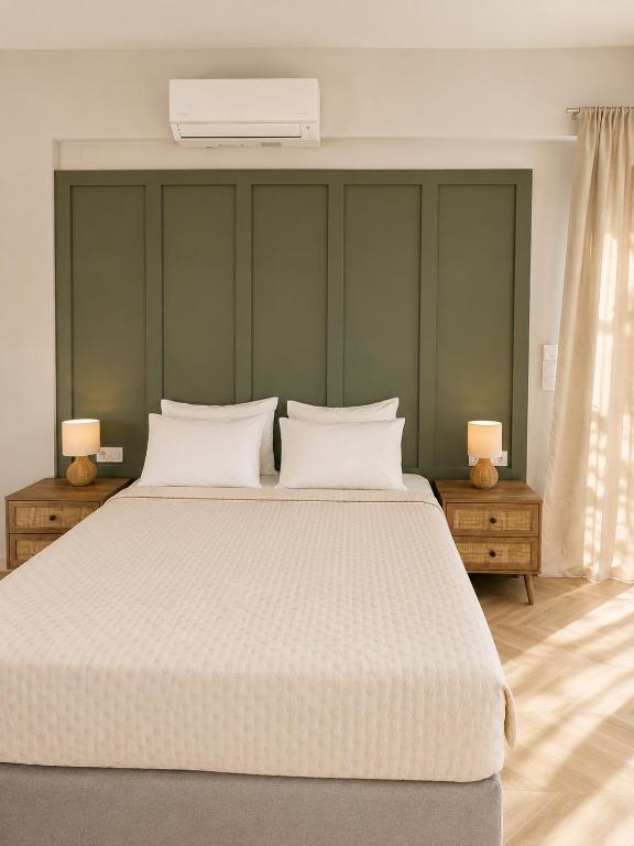 a bedroom with a large white bed with two lamps at Maria's Studios in Frangokastello