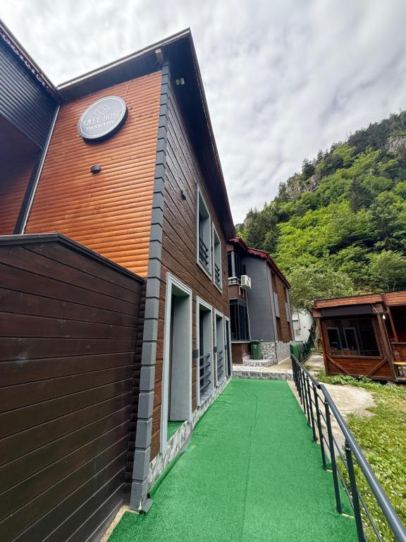 a house with a green floor next to a building at Tree Rose Suite in Uzungöl