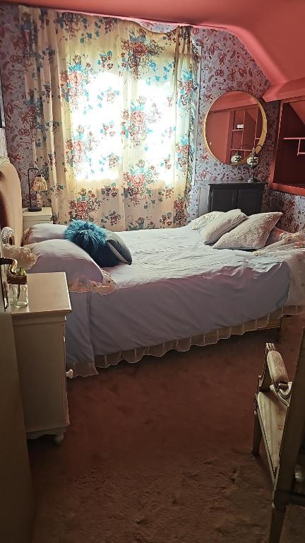 a bedroom with a large bed and a window at Chambre d'hôtes Le Havre in Saint-Coulomb