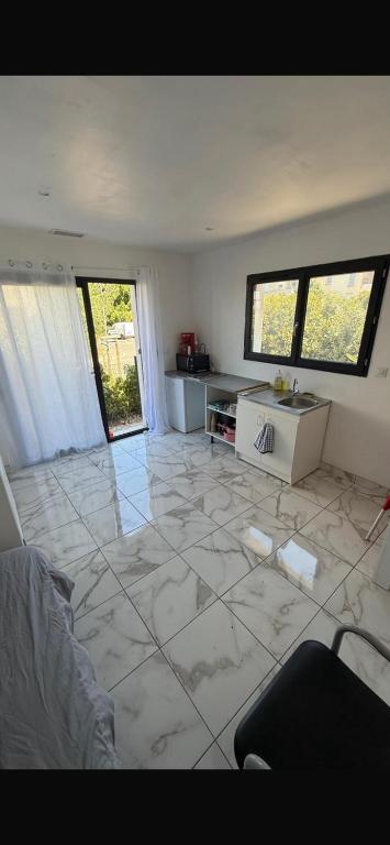 a living room with a large white tile floor at Studio dans une villa in Perpignan