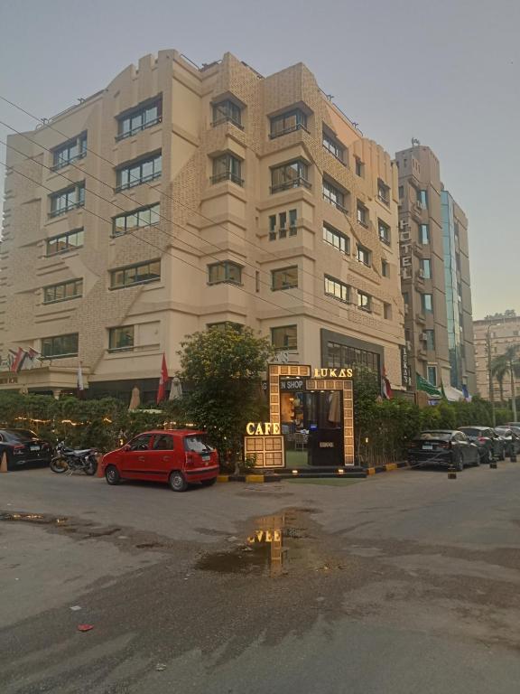 a red car parked in front of a large building at Boutique Hotel El Mesaadia in Cairo