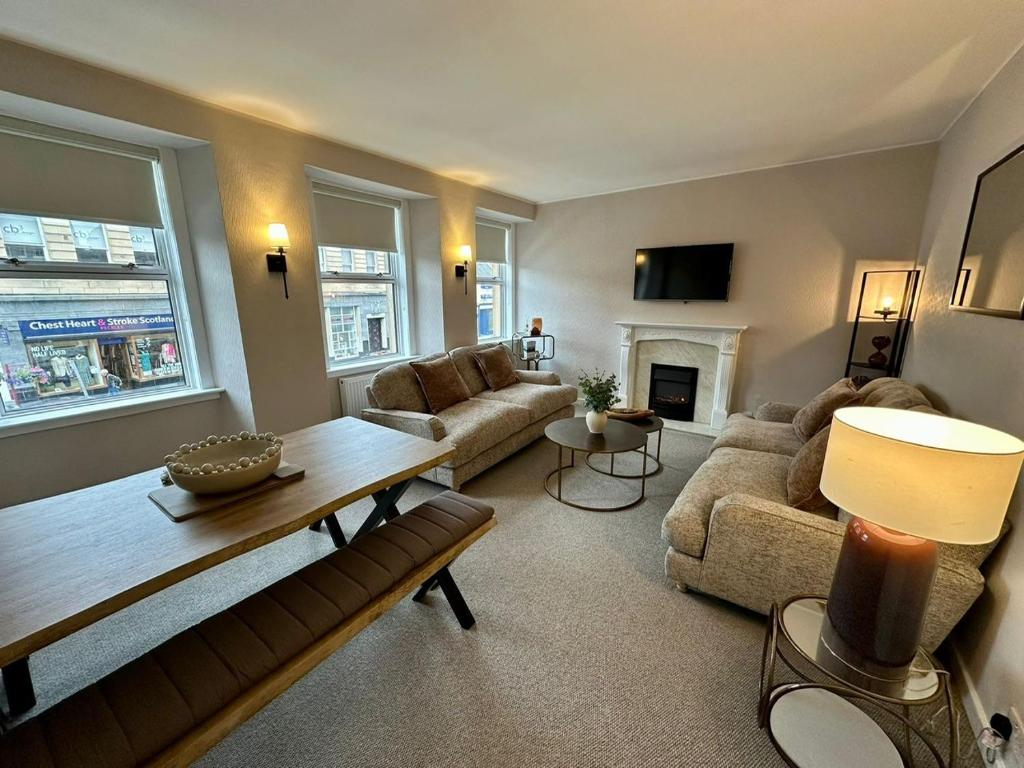 a living room with a couch and a table at Stay 55 in Peebles
