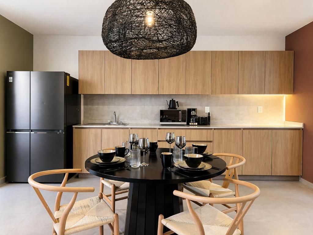a kitchen with a table and chairs and a refrigerator at Casa DUALIA in San Miguel de Allende