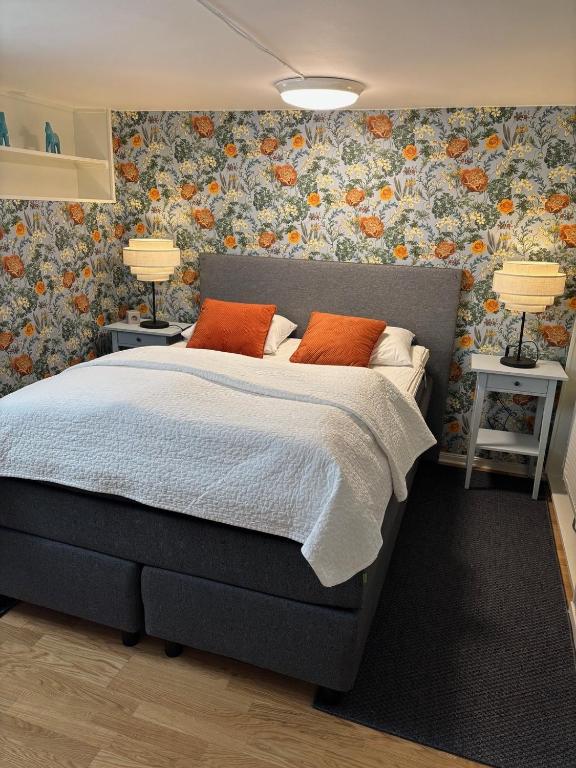 a bedroom with a bed with orange pillows on it at Gillestugan in Rättvik