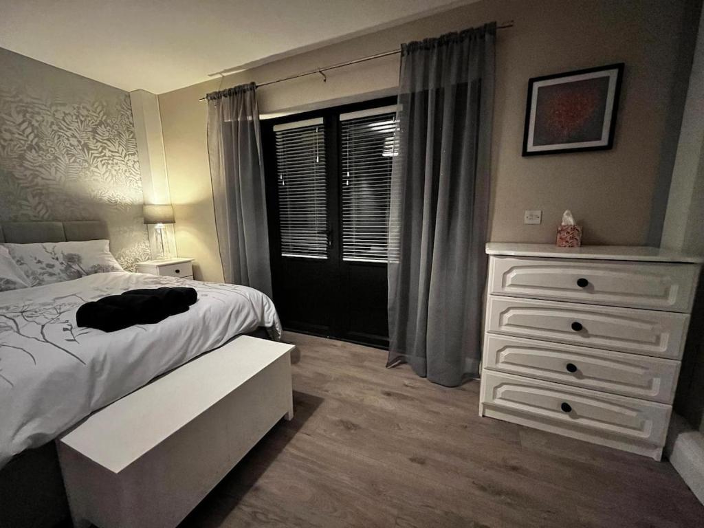 a bedroom with a bed and a dresser and a window at Five Valleys, Ballinastraw in Bunclody