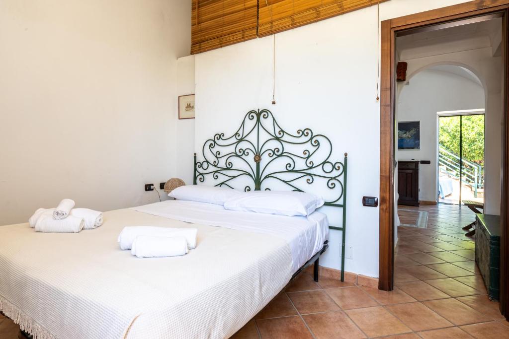 a bedroom with a large white bed with white pillows at Casa Clotilde - nel Cuore di Capri in Capri