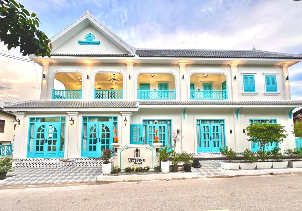 a large white house with blue shutters at Luangaloun Guesthouse in Luang Prabang