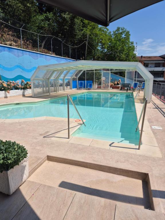 a large swimming pool with a glass enclosure at Hotel Astoria in Tabiano