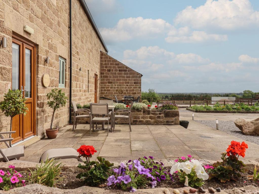 a patio with chairs and flowers next to a building at Miller's Wheel in Harrogate