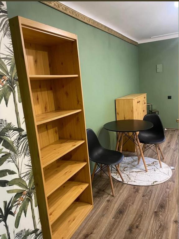 a room with a table and a book shelf at Second&Home 3 in Kalisz
