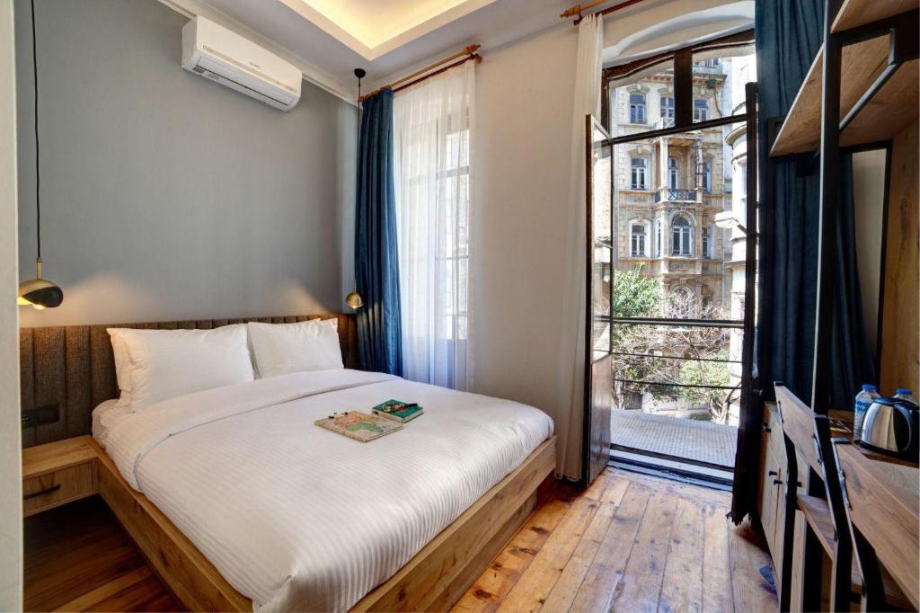 a bedroom with a bed and a large window at Medusa Historic Luxury Hotel Galata in Istanbul