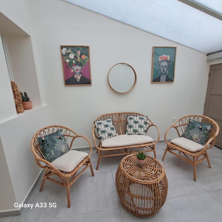 a room with three chairs and a table and a mirror at LE 37 croix in Gennes
