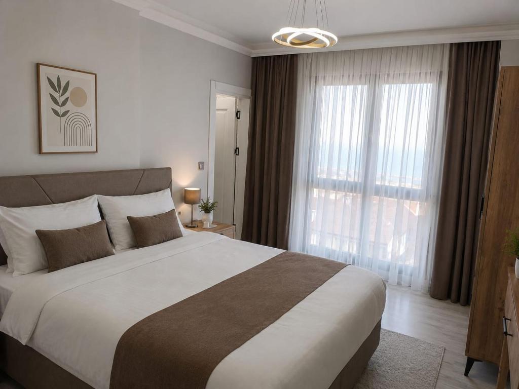 a bedroom with a large bed and large windows at Airport Deluxe Suites Otel in Trabzon