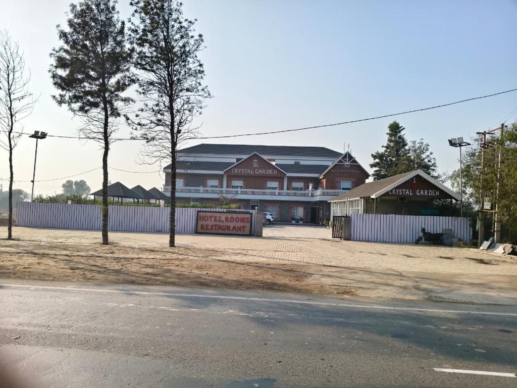 a large building with a fence in front of it at Crystal Garden in Lalru