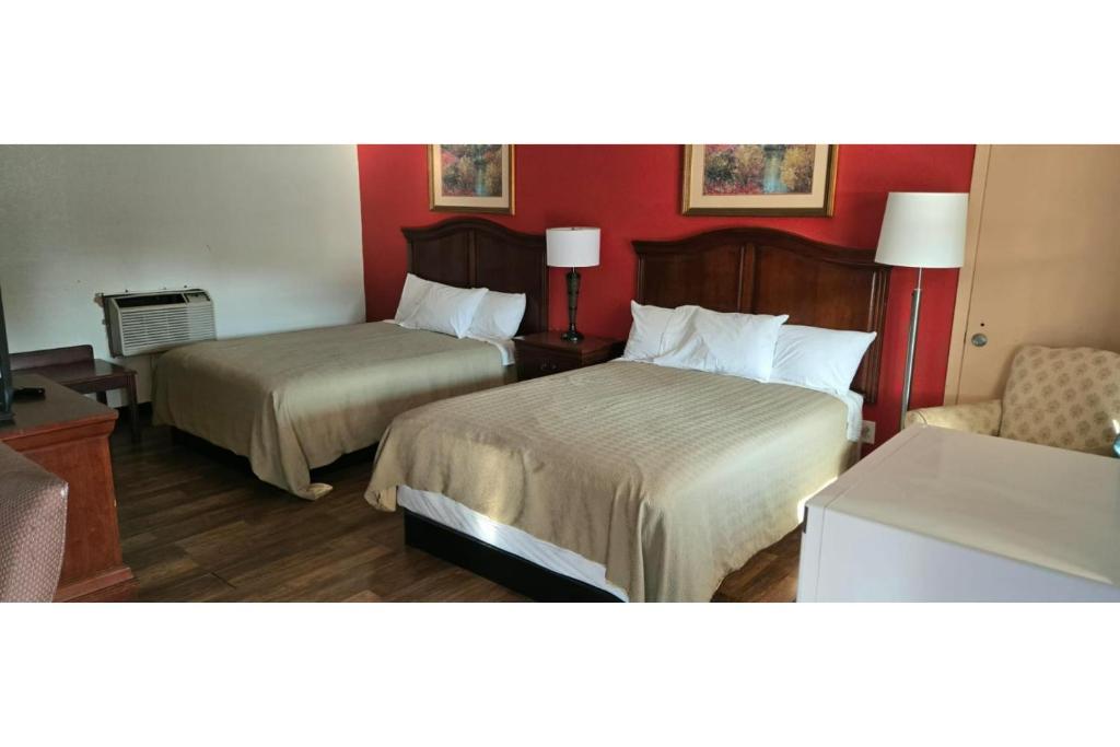 a hotel room with two beds and a chair at Lion Inn Albemarle By Hotel O Near US 52 in Albemarle