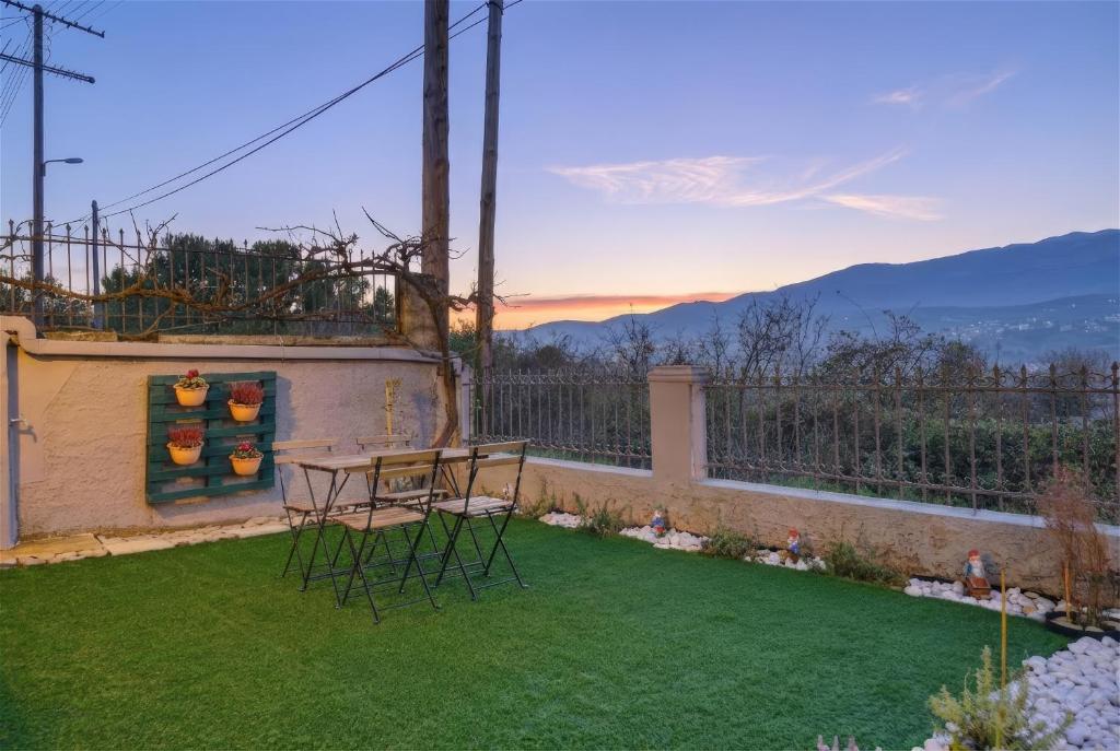 a patio with a table and chairs on a lawn at Calma Ioannina Apartment in Ioannina