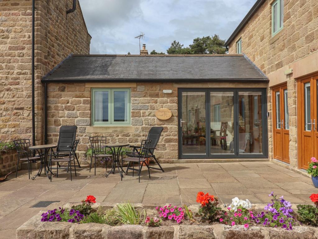 a patio with chairs and a table in front of a building at Shepherd's Crook in Harrogate
