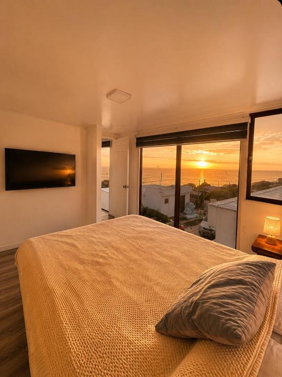 a bedroom with a large bed and a large window at Cabaña el Sol in La Boca