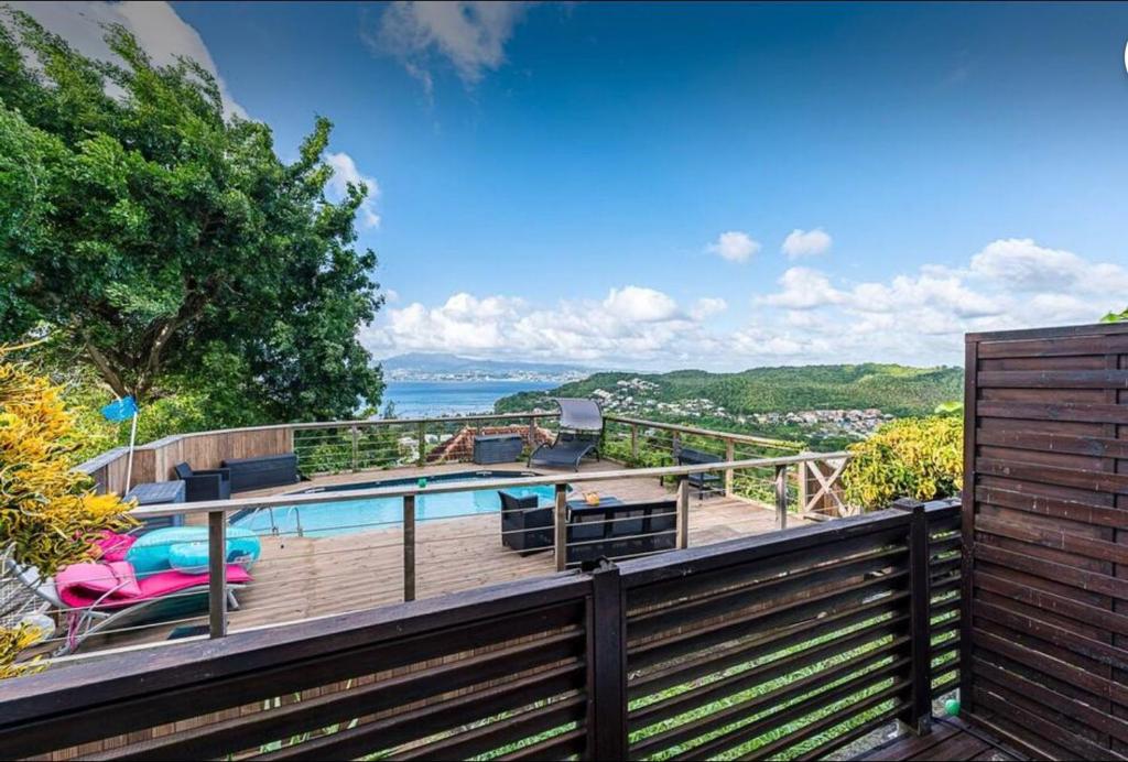 a house with a swimming pool on a wooden deck at 2-3 personnes - Vue Mer et Piscine - Anse à l Âne - trois Îlets - Plage 2 min en voiture in Les Trois-Îlets
