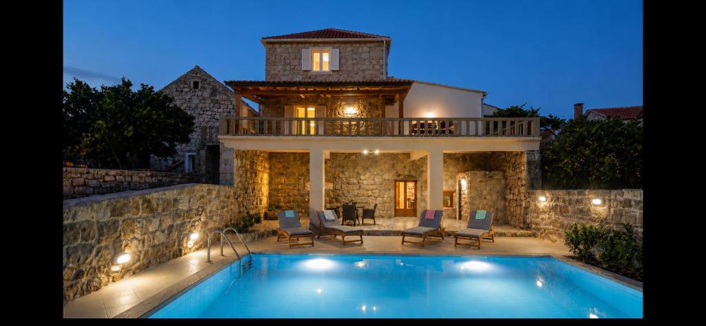 a villa with a swimming pool and a house at Villa Bellezza in Čilipi
