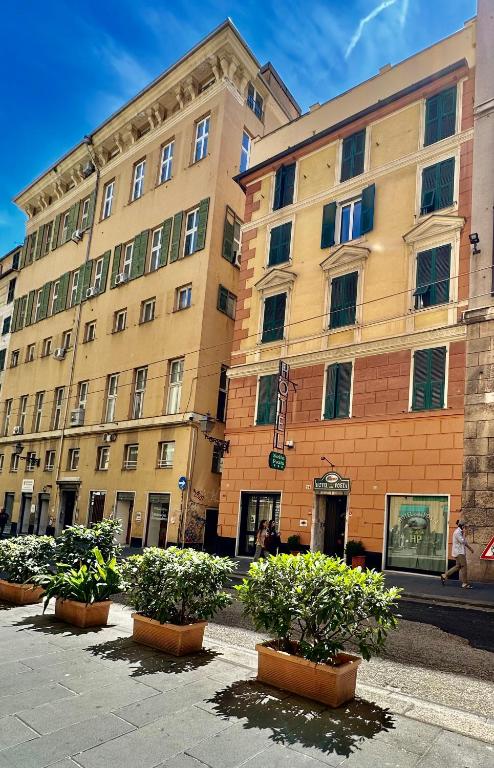 un grande edificio con piante in vaso davanti di Albergo Posta a Genova
