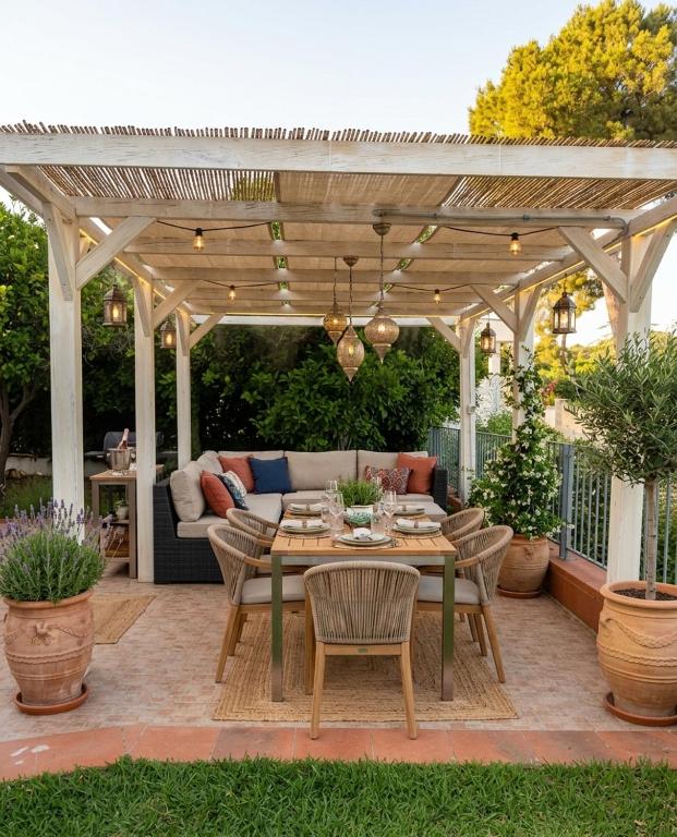 a patio with a table and chairs under a pergola at Appartamenti in Villa Polimnia in Fontane Bianche