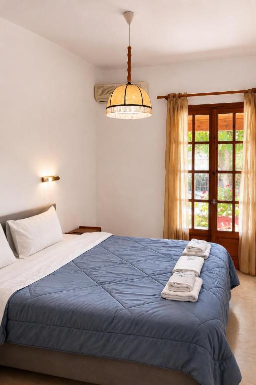 a bedroom with a large bed with a blue blanket at Gian Petro Apartments in Sidari
