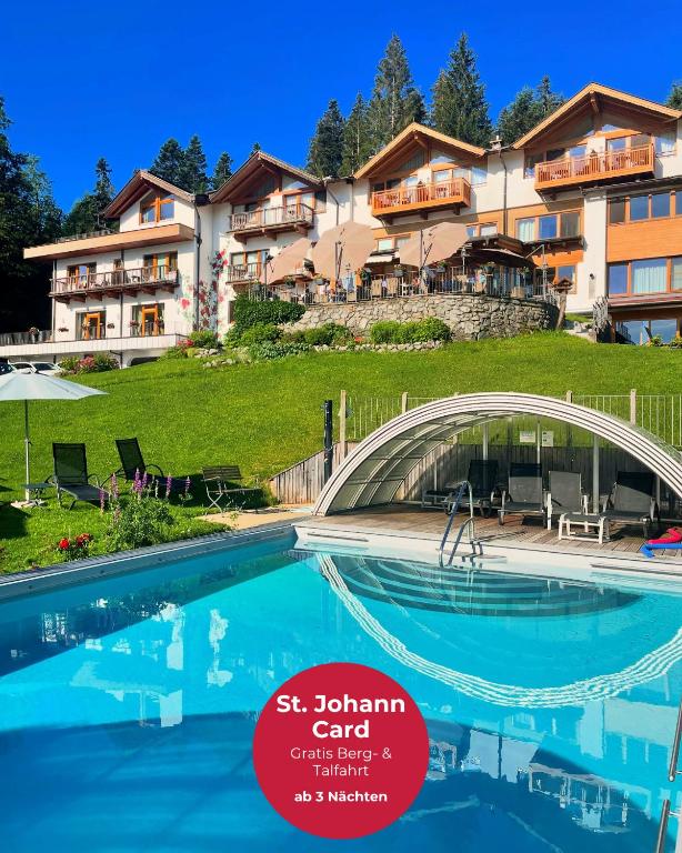 a hotel with a swimming pool in front of a building at Gartenhotel Rosenhof bei Kitzbühel in Oberndorf in Tirol