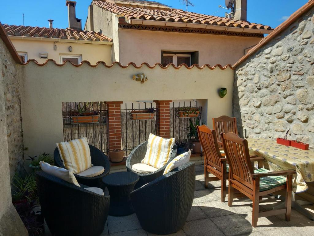 a patio with chairs and a table and a building at La Petite Maison de Caractere Catalan in Argelès-sur-Mer
