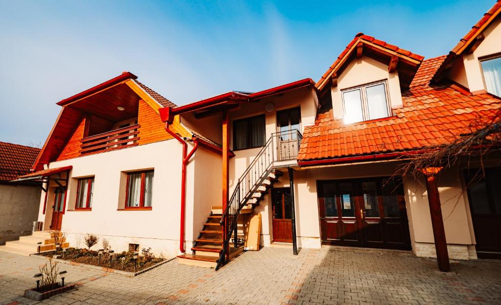 a house with an orange roof and a staircase at Vila Hubertus in Avrig